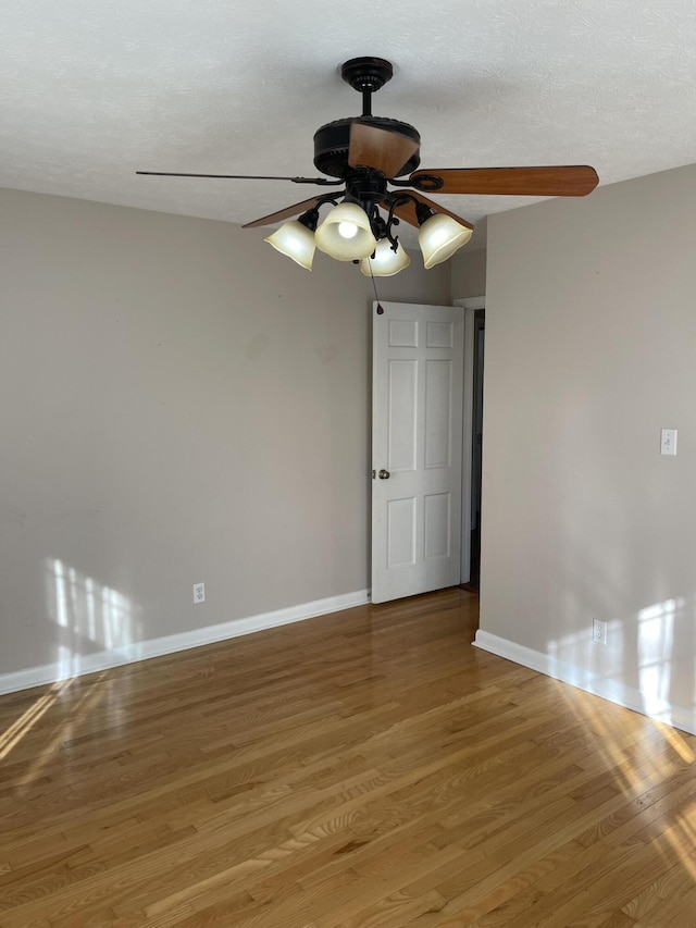 empty room featuring a textured ceiling, hardwood / wood-style flooring, and ceiling fan