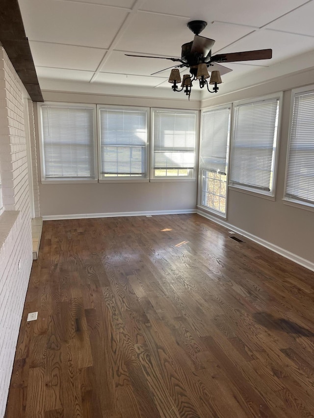 unfurnished room featuring dark wood-style floors, visible vents, baseboards, and ceiling fan