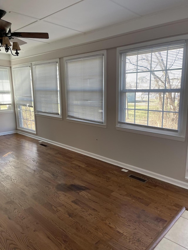 unfurnished room featuring visible vents, ceiling fan, plenty of natural light, and baseboards