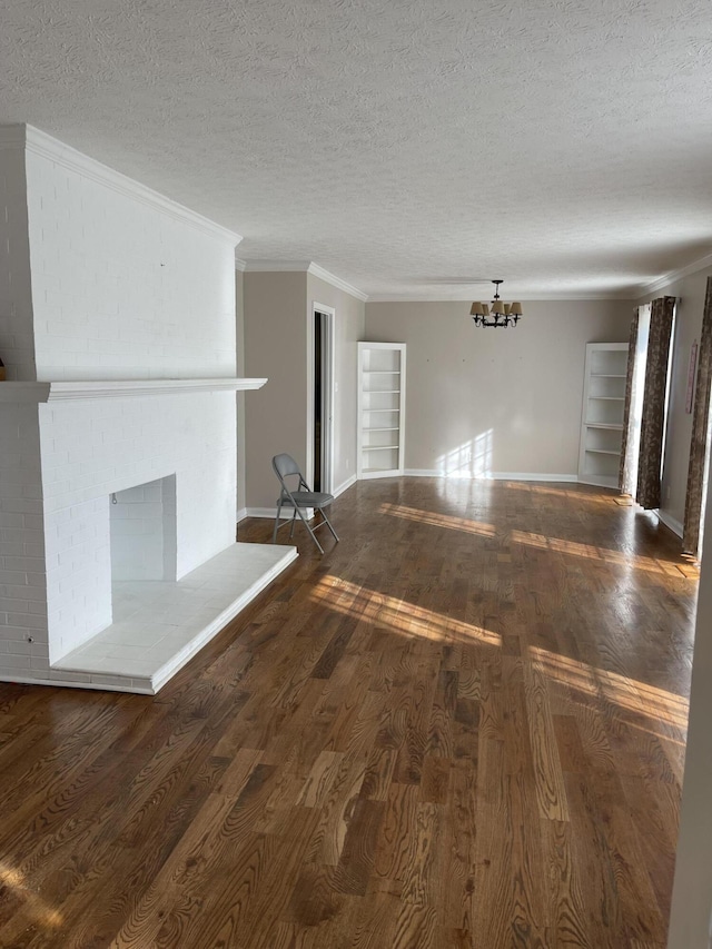 unfurnished living room featuring a textured ceiling, a large fireplace, dark hardwood / wood-style flooring, and crown molding