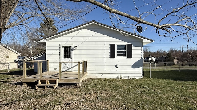 back of house with a deck and a lawn