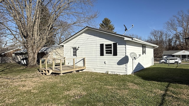 back of house featuring a wooden deck and a lawn