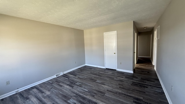 unfurnished bedroom featuring a textured ceiling and dark hardwood / wood-style flooring