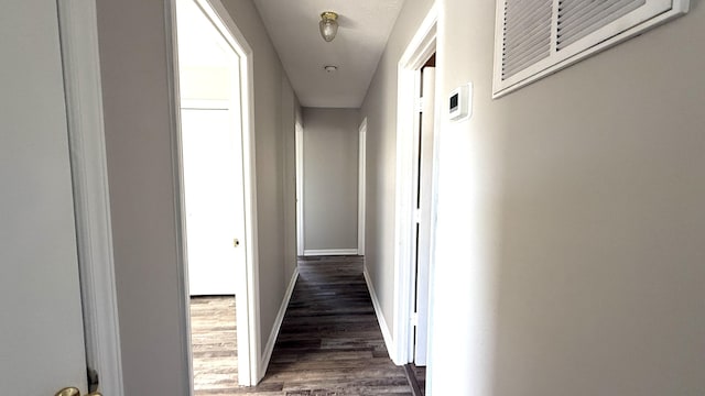 corridor with dark hardwood / wood-style flooring