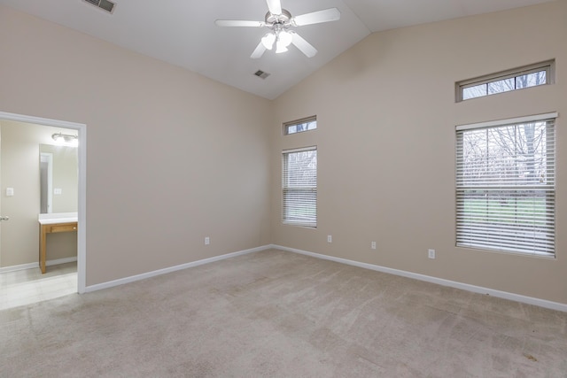 carpeted spare room with ceiling fan and high vaulted ceiling