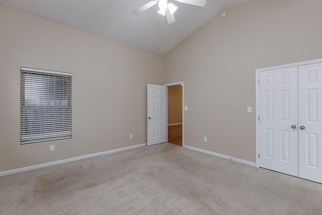 spare room with ceiling fan, light colored carpet, and high vaulted ceiling