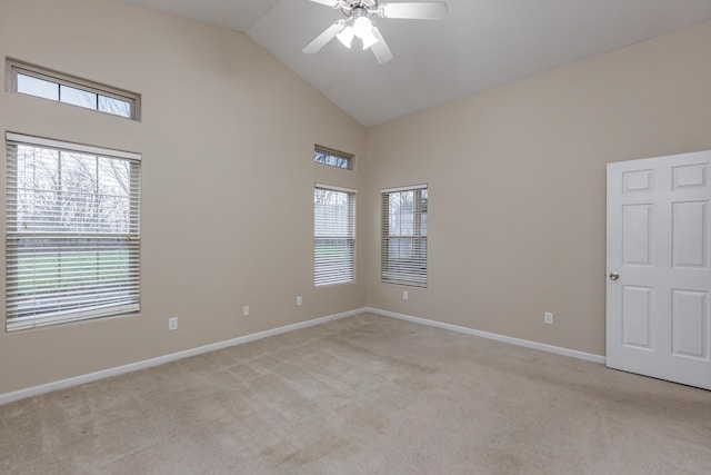 spare room with ceiling fan, high vaulted ceiling, and light carpet