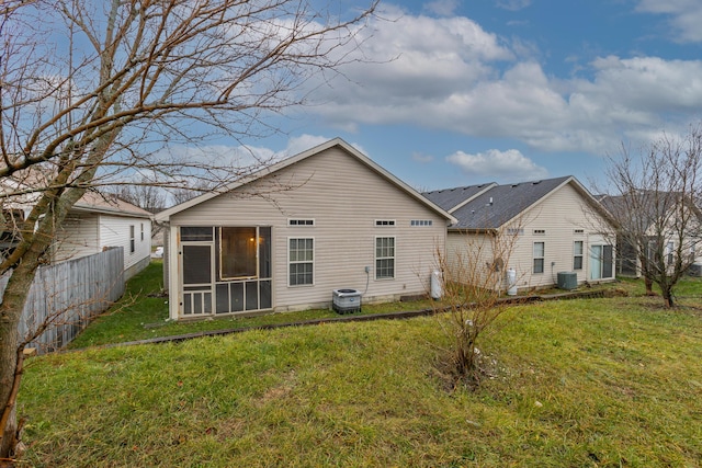 back of property featuring a sunroom, central air condition unit, and a yard