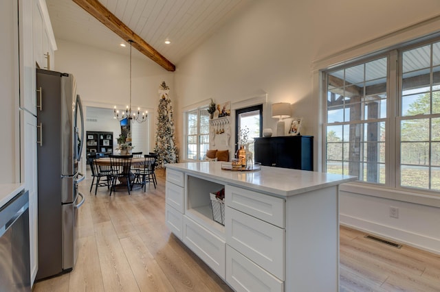 kitchen with white cabinetry, hanging light fixtures, a wealth of natural light, and stainless steel appliances