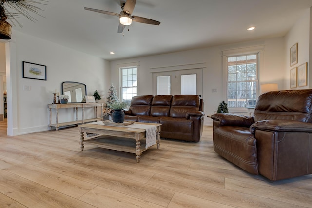 living room with ceiling fan and light hardwood / wood-style floors