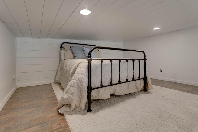 bedroom with hardwood / wood-style flooring and wood ceiling