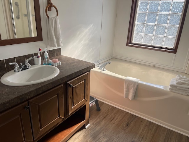 bathroom featuring a washtub, hardwood / wood-style floors, and vanity