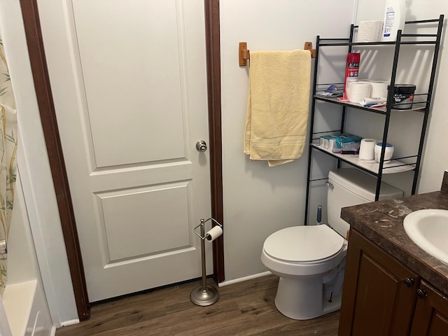 bathroom with wood-type flooring, vanity, and toilet