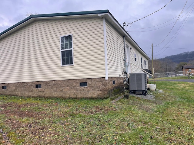 view of property exterior with a yard and cooling unit