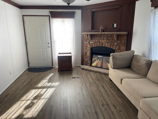 living room featuring a stone fireplace, ceiling fan, and dark hardwood / wood-style flooring