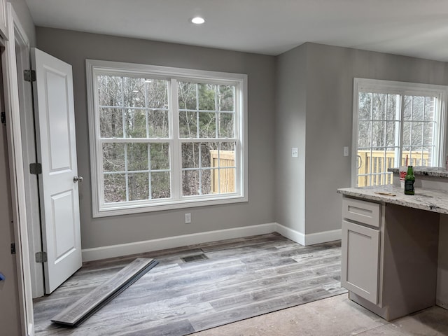 unfurnished dining area featuring a wealth of natural light and light hardwood / wood-style flooring