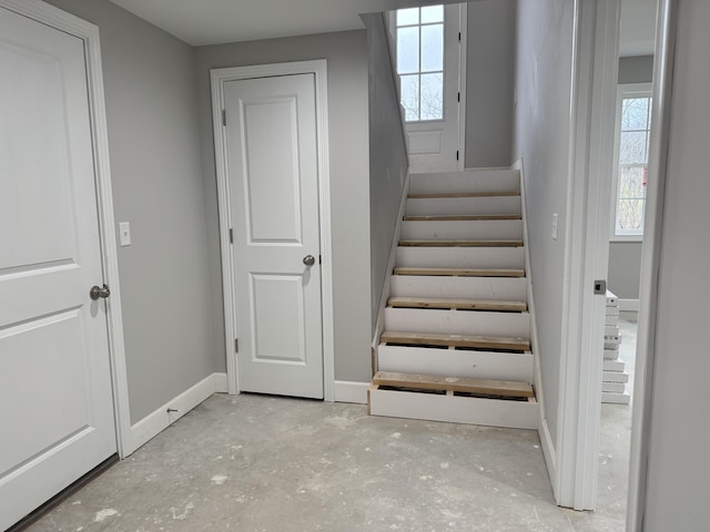 staircase with a wealth of natural light and concrete floors