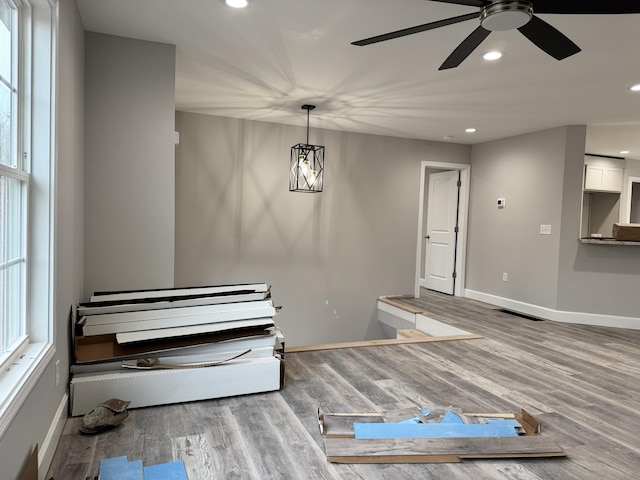 misc room with hardwood / wood-style floors and ceiling fan with notable chandelier