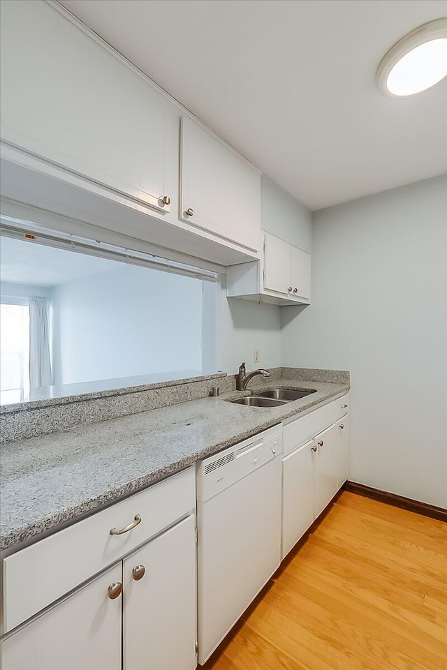 kitchen with white cabinets, light stone counters, sink, dishwasher, and light hardwood / wood-style floors