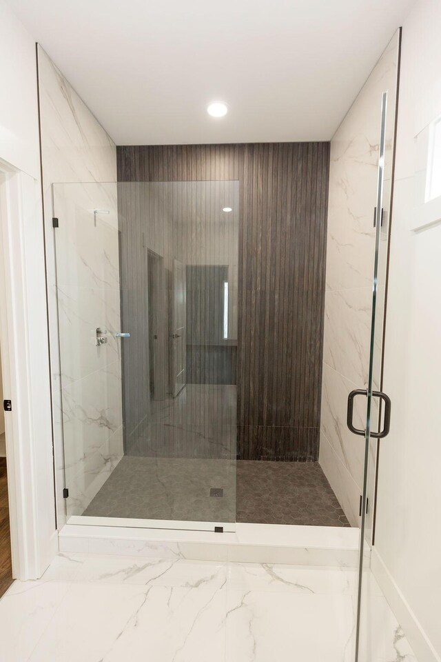 bathroom featuring recessed lighting, marble finish floor, and a marble finish shower