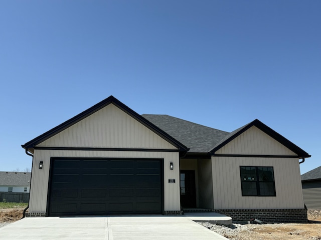 modern farmhouse style home featuring driveway, roof with shingles, and a garage
