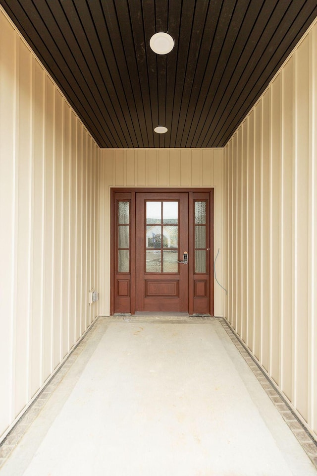 doorway to property featuring board and batten siding and a patio area