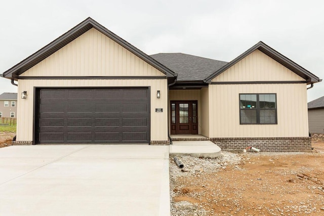 view of front of property with an attached garage, driveway, and roof with shingles