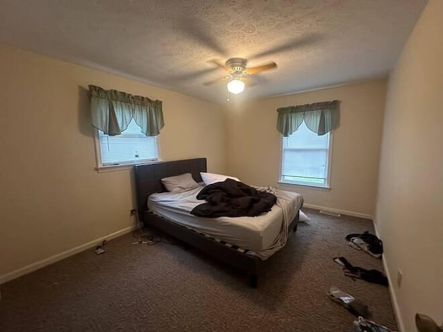 carpeted bedroom with ceiling fan and a textured ceiling