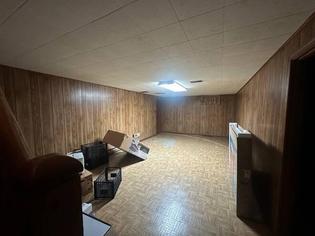 interior space with light parquet floors and wood walls