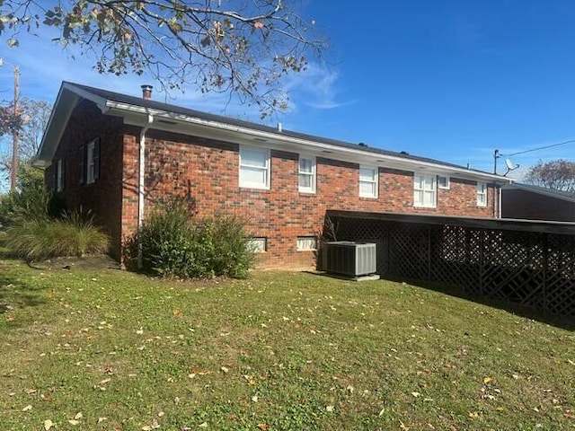 back of house featuring central AC and a yard