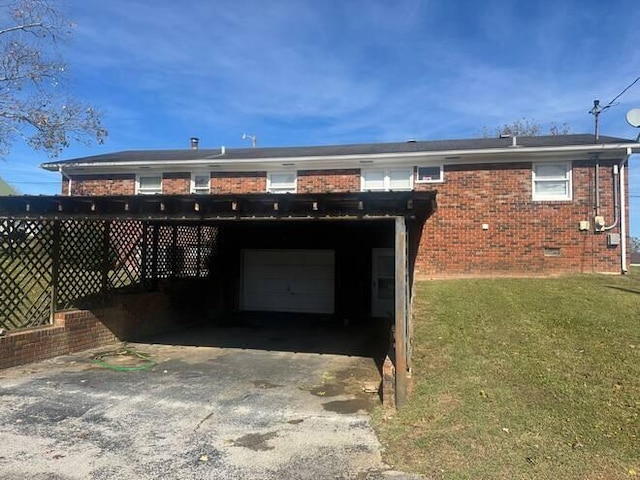 back of house with a garage, a carport, and a lawn