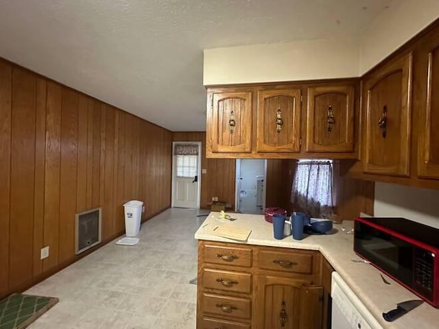 kitchen featuring wooden walls and dishwasher