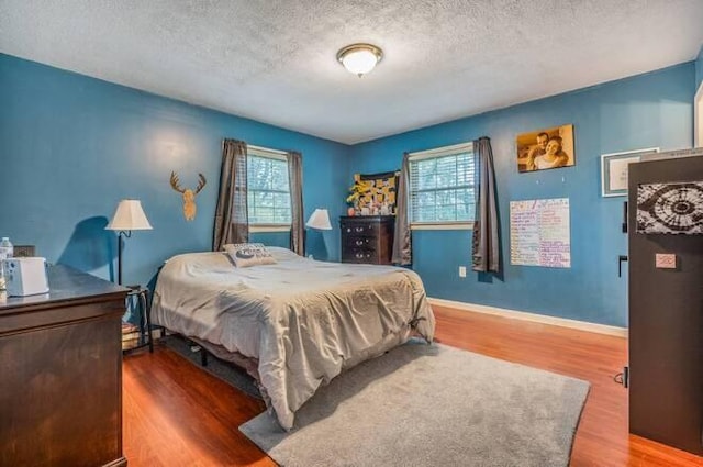 bedroom with a textured ceiling and hardwood / wood-style flooring