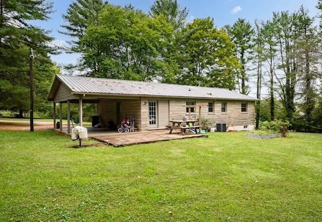 rear view of property with central AC, a patio area, and a lawn