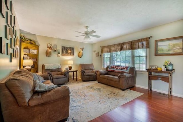 living room with dark hardwood / wood-style flooring and ceiling fan