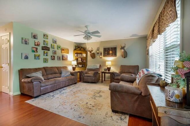 living room featuring ceiling fan and dark hardwood / wood-style floors