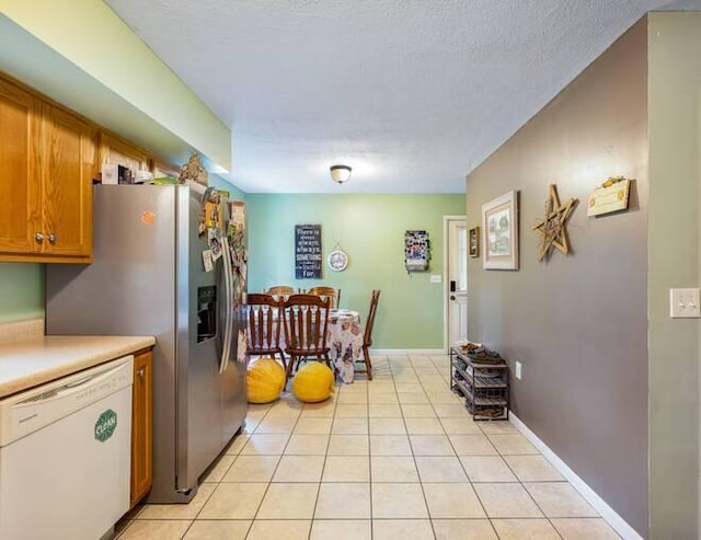 kitchen with dishwasher, light tile patterned floors, and a textured ceiling