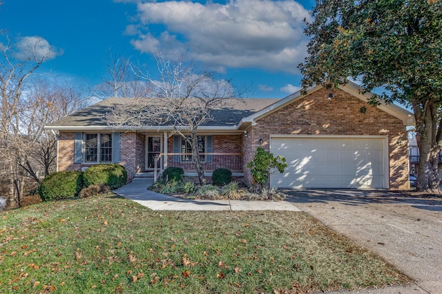 ranch-style home featuring covered porch, a garage, and a front yard