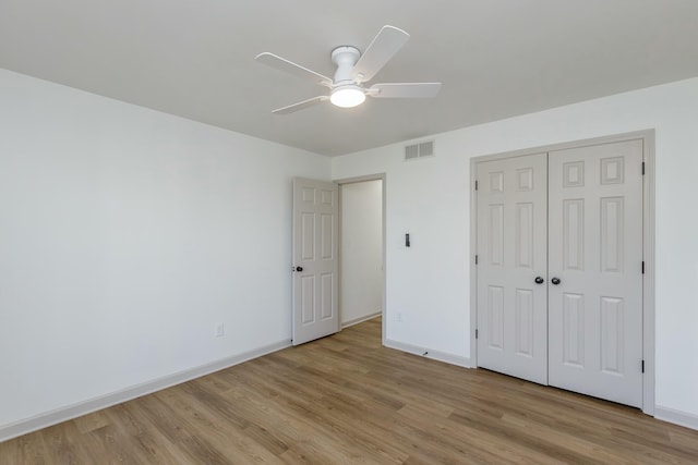 unfurnished bedroom with a closet, light hardwood / wood-style flooring, and ceiling fan