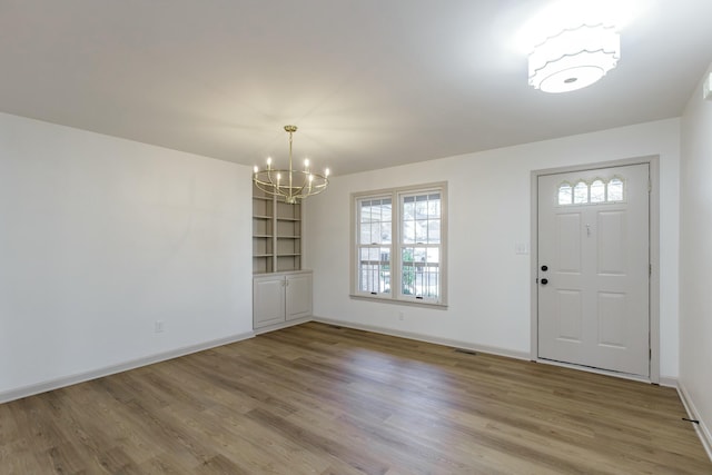 entrance foyer featuring a notable chandelier and wood-type flooring