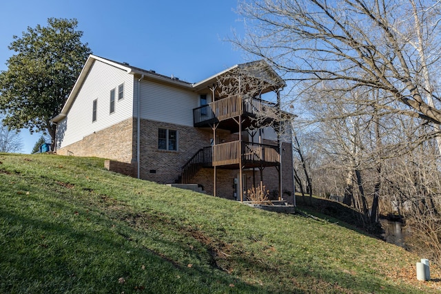 back of house featuring a lawn and a balcony