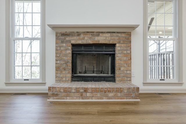 interior details featuring hardwood / wood-style flooring and a brick fireplace