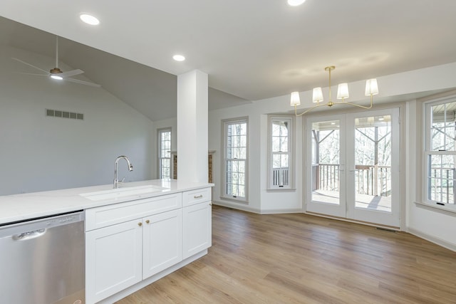 kitchen featuring light stone countertops, vaulted ceiling, sink, dishwasher, and white cabinetry