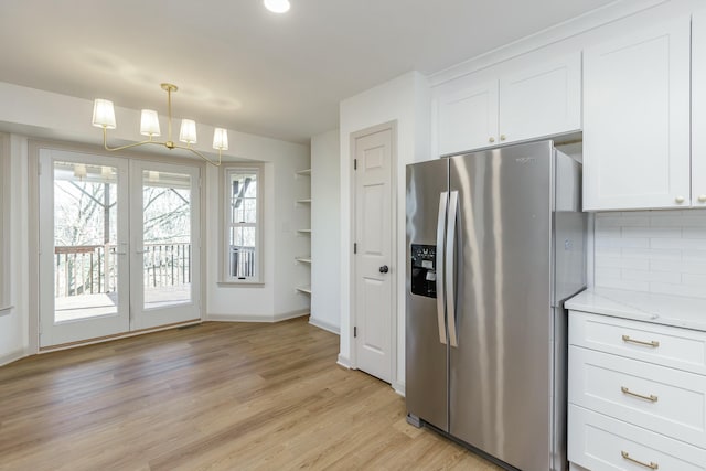 kitchen featuring backsplash, stainless steel fridge, and white cabinets