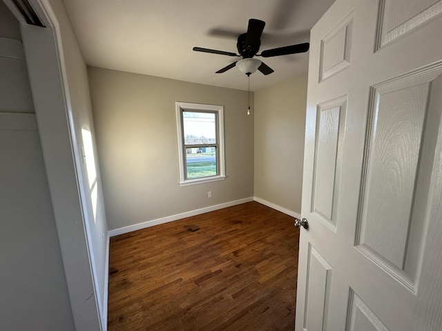 unfurnished room with ceiling fan and dark hardwood / wood-style flooring