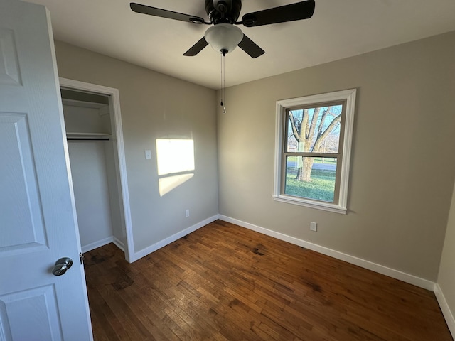 unfurnished bedroom with ceiling fan, dark hardwood / wood-style floors, and a closet