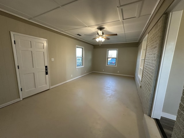 empty room featuring ceiling fan and concrete flooring