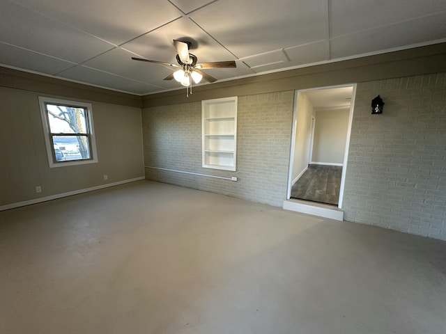 interior space featuring concrete flooring, built in shelves, ceiling fan, and brick wall