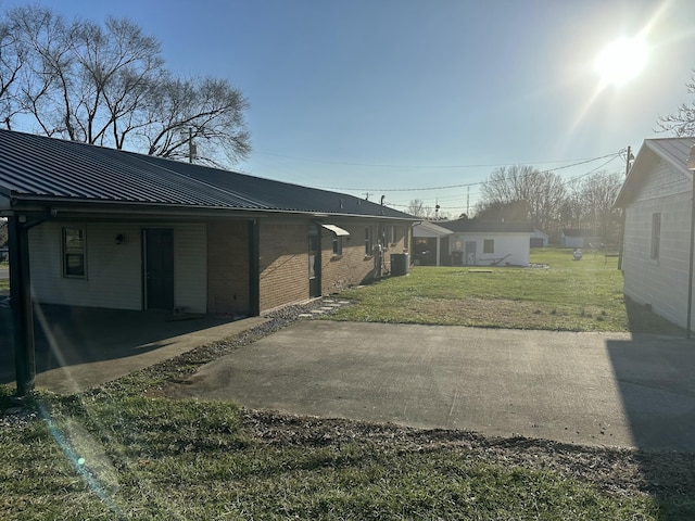 exterior space featuring a yard, a carport, and cooling unit