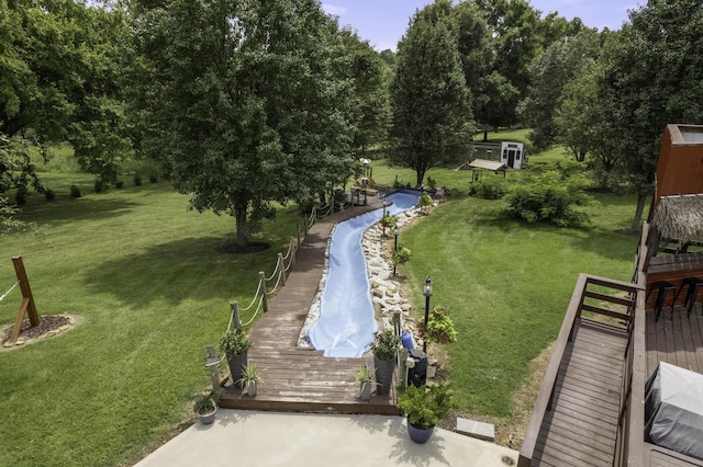 view of property's community featuring a lawn and a wooden deck